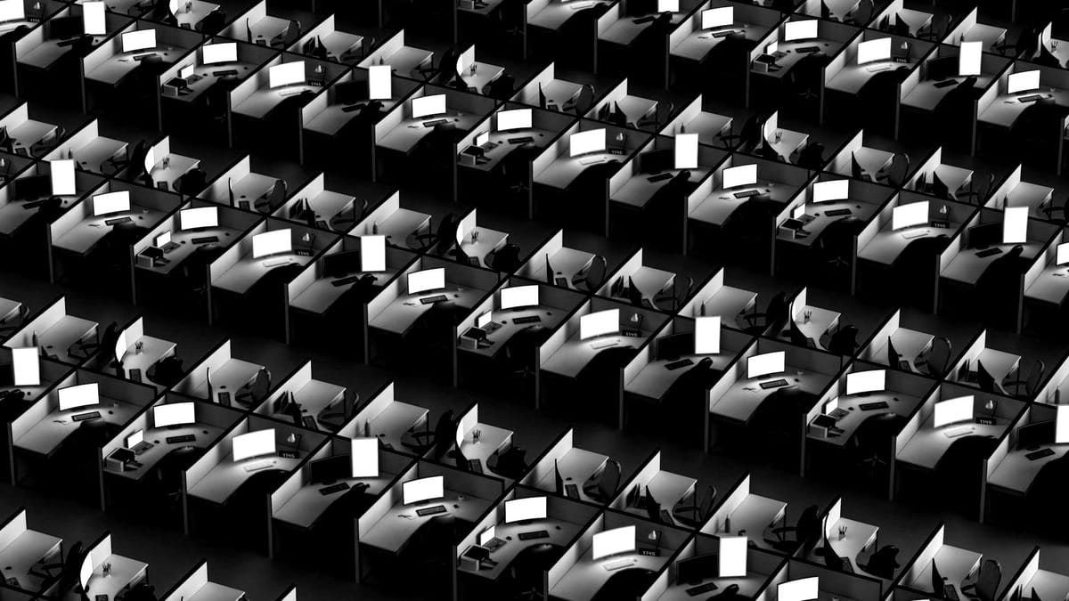 Rows and rows of office cubicles, each with computer screens and desks. There are no people.